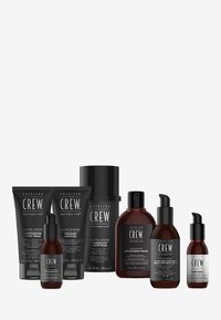 Set med groomingprodukter i svart och amberförpackning. Inkluderar tuber och flaskor med etiketter för rakkräm, gel, skum och serum.