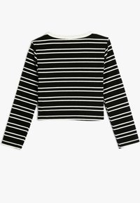 Sort-hvid stribet langærmet crop top i ribbet stof. Har en rund halsudskæring og kontrasterende hvid kant på ærmerne og nederkanten.