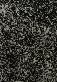 Tessuto a maglia con un motivo mélange nero e grigio caratterizzato da una trama morbida. Il design include toni variabili e leggere sfumature qua e là.