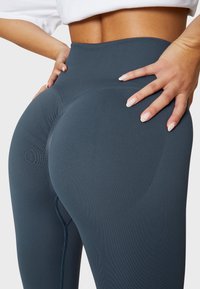 Hochtaillierte, dunkelblaue Leggings mit geripptem Design und konturierenden Nähten. Bietet eine glatte Oberfläche und einen engen Sitz an der Taille und den Hüften.