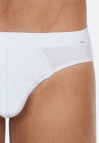 Weiße Unterwäsche aus glattem Material, mit einem transparenten Einsatz an der Seite und einem elastischen Bund mit Branding.