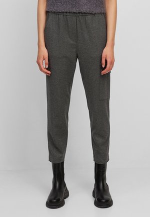 Pantalons gris effilés avec une taille élastique et une poche latérale, fabriqués en tissu doux. Associés à des bottines noires.