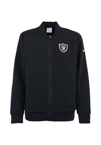 Giacca nera con zip realizzata in tessuto liscio, con logo dei Raiders sul petto e colletto alto. Maniche e orlo a costine.