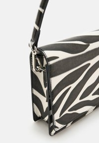 Tasche im Zebra-Design aus Leder mit glänzender Oberfläche, strukturiertem Design und abnehmbarem Schulterriemen mit silberfarbenen Beschlägen.