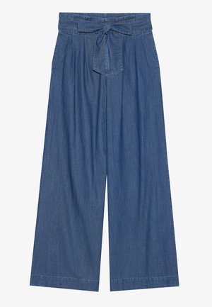 Džínové culottes s vysokým pasem, širokými nohavicemi a látkovým páskem. Textura je měkká a barva je středně modrá.
