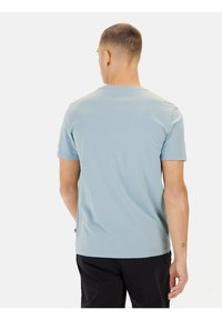 Lyseblå kortærmet T-shirt i bomuld med rund halsudskæring. Har en lige pasform og synlige sømme ved kanten og ærmerne.