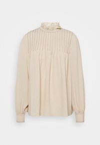 Blusa beige a maniche lunghe con colletto alto a volant, dettagli verticali a righe e lati arricciati. Tessuto liscio e polsini aderenti.