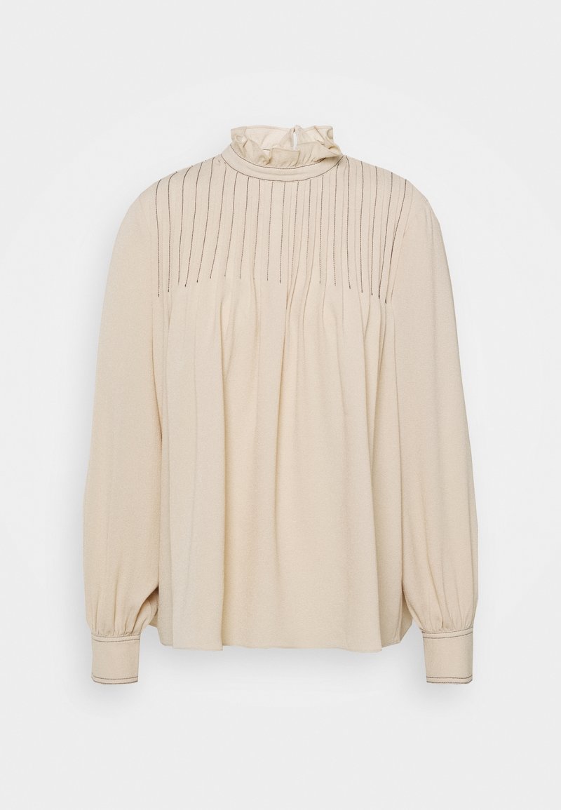 Blouse beige à manches longues avec un col haut froncé, des détails en pinces verticales et des côtés froncés. Texture lisse et poignets ajustés.
