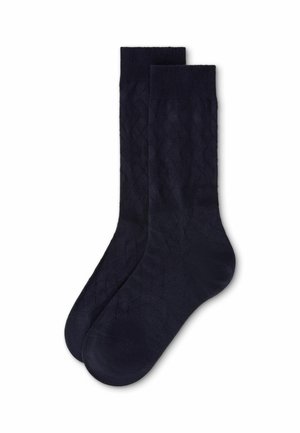Par de calcetines azules marino lisos con patrón sutil de textura de diamante, colocados planos sobre un fondo blanco.