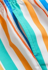Wielokolorowa tkanina w paski z poziomymi liniami w turkusie, pomarańczy i bieli, z elastyczną talią oraz kontrastującym przeszyciem.
