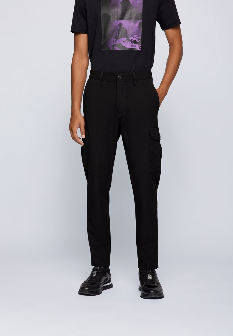 Černé cargo kalhoty se dvěma bočními kapsami, slim fit a hladkým povrchem. Kombinujte s černým tričkem s grafikou a černými teniskami.