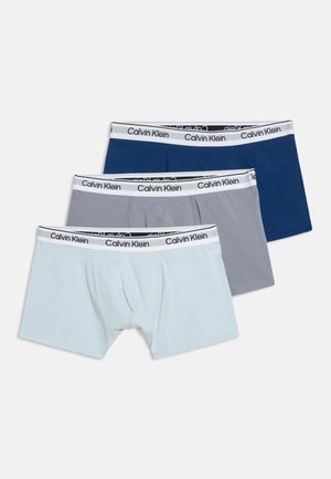 Tre paia di boxer da uomo in azzurro chiaro, grigio e blu navy con fascia elastica bianca con marchio Calvin Klein.