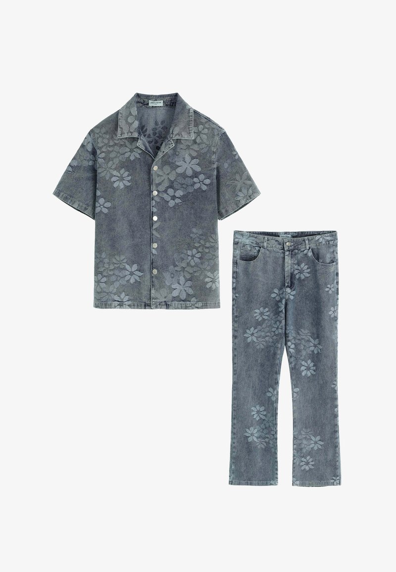 Chemise en denim à manches courtes et à boutons sur le devant, assortie à un jean, le tout dans une teinte grise ornée de motifs floraux.