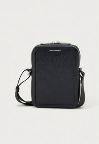 Μικρή μαύρη ορθογώνια τσάντα χιαστί με ανάγλυφο γεωμετρικό σχέδιο, ασημένιο φερμουάρ και ρυθμιζόμενο λουρί από τον Karl Lagerfeld.