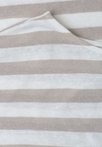 Tissu plié avec des rayures horizontales beige et blanches, montrant une texture douce et un léger éclat sur les rayures beiges.