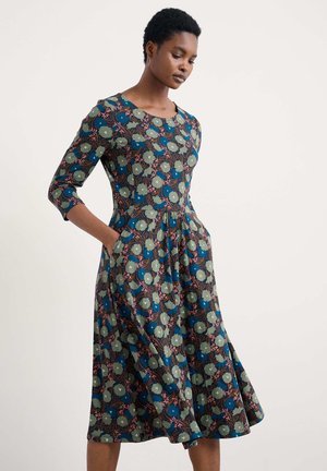 Blumenkleid mit rundem Ausschnitt, Dreiviertelärmeln und Taschen, aus einem Stoff mit blauen, grünen und rosa Mustern. A-Linie.