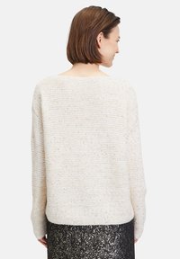 Cremfarbener Strickpullover mit lockerem Schnitt, breitem Ausschnitt und langen Ärmeln, aus strukturiertem Stoff mit subtilen Glitzereffekten.