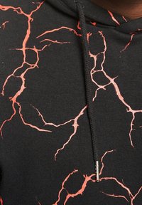 Zwarte hoodie met trekkoord met felrode bliksem- of scheurpatronen over de stof.