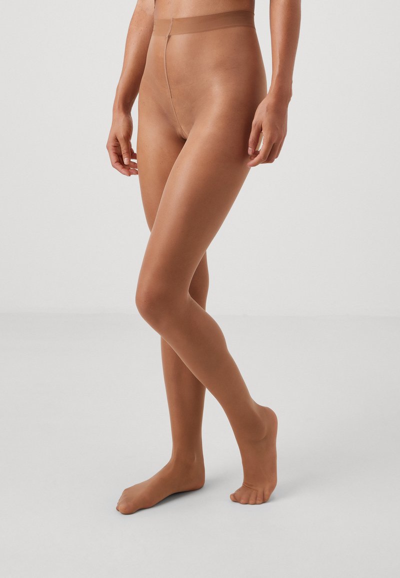 Nude sheer tights with a smooth texture and a soft waistband, designed to fit comfortably and provide a natural leg appearance.