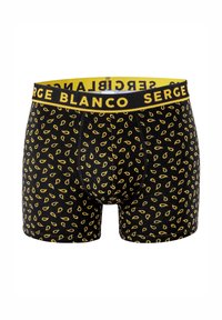 Boxer noir avec un motif de feuilles jaunes, taille élastique avec le texte "SERGE BLANCO", et une coupe ajustée.
