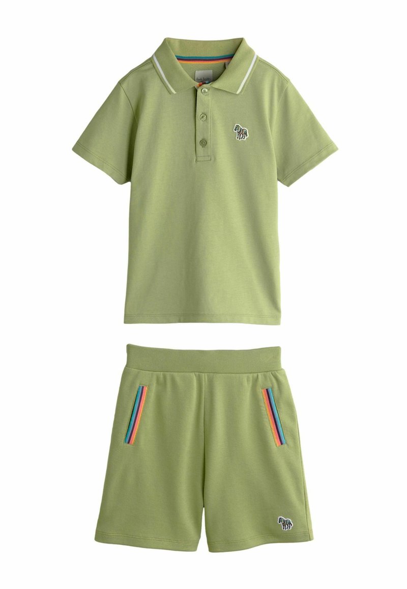 Hellgrünes Baumwoll-Poloshirt mit weißem Kragen und kleinem Elefanten-Stickerei, kombiniert mit passenden Shorts mit regenbogenfarbenen gestreiften Taschen.