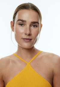 Geel geribbelde haltertop met kruislings strap, gemaakt van een textuurstof, met een slim fit ontwerp en een subtiele glans. Eenvoudige en moderne esthetiek.