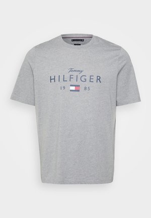 Szara bawełniana koszulka z krótkimi rękawami, okrągłym dekoltem oraz nadrukiem z napisem "Tommy HILFIGER 1985" i małym logo z przodu.