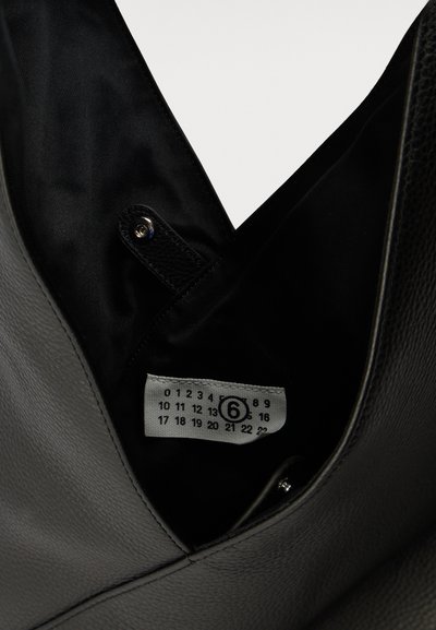 Black leather bag with a snap button strap and a white label inside showing numbers 0 to 23 with number 6 circled.