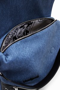Zaino in denim con una tasca anteriore con zip. Presenta un interno nero con un design cartone animato, cerniere argento e un esterno blu texturizzato.