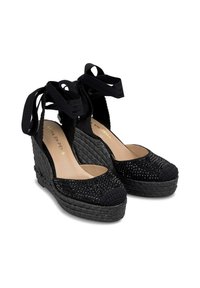 Espadrille noire à semelle compensée avec texture tissée, embout en perles et liens en ruban à la cheville. Présente une semelle plateforme pour plus de hauteur.