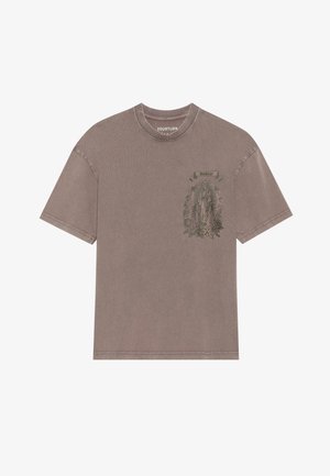 Brown oversized cotton t-shirt featuring a green graphic print of a figure with flowers and text on the front, short sleeves, and a crew neck.