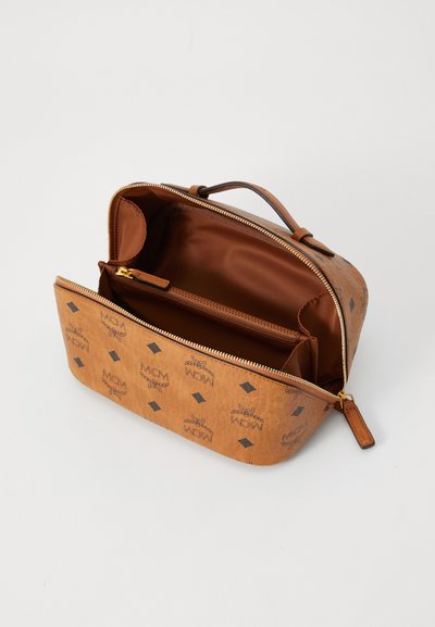 Braune Lederhandtasche mit goldenem Reißverschluss und Griff, ausgestattet mit einer Innentasche und einem Logomuster auf der Außenseite. Glatte Oberfläche insgesamt.