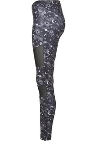 Svarta leggings med ett himmelskt tryck av planeter och stjärnbilder; har nätpaneler på sidorna för andningsförmåga och flexibilitet.