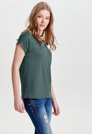 Teal kortermet skjorte i et mykt, glatt stoff, med en avslappet passform. Kombinert med blå jeans med glidelåsdetaljer og slitte aksenter.