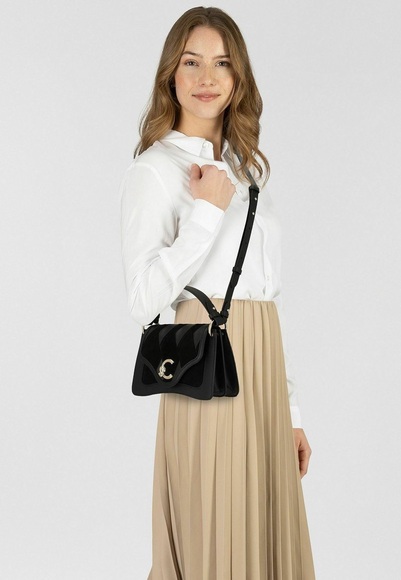 Borsa a tracolla in similpelle nera con finitura lucida, caratterizzata da un design testurizzato, dettagli in oro e tracolla removibile.