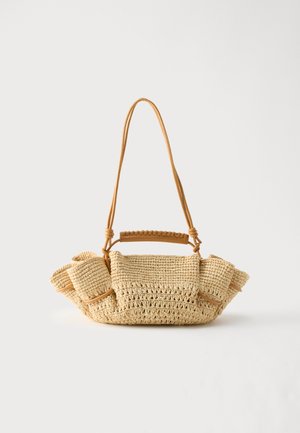 Geweven beige handtas met een lange dunne riem en geplooide zijkanten, met een korte handgreep omwikkeld met leer voor draagopties.
