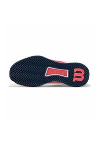Suela de zapatilla deportiva Wilson en azul marino con acentos en rosa. Presenta un patrón de tracción en espiga y un logo "W" en relieve para mejorar la adherencia.