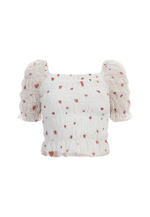 Balta puff-sleeve blūze ar smockotu augšdaļu, kurā ir sarkanu sirdsspēku raksts un punktains tekstūra. Īsas volānu piedurknes uzlabo dizainu.