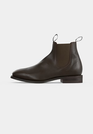 Bottine Chelsea en cuir marron foncé avec panneaux latéraux élastiques et languettes à tirer sur un petit talon empilé, vue du côté extérieur.