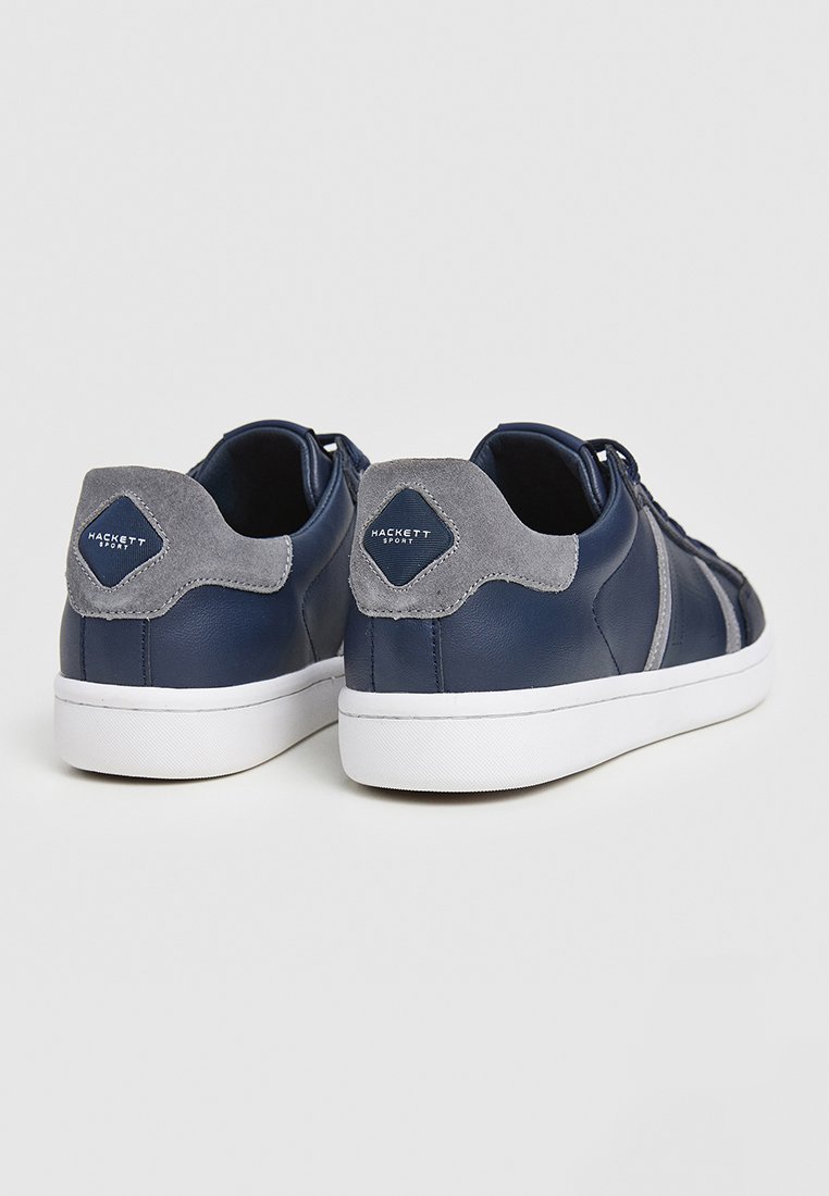 Baskets en cuir bleu marine avec des accents en daim gris, semelles en caoutchouc blanc et un onglet arrière brandé en forme de diamant. Design de lacets simple.