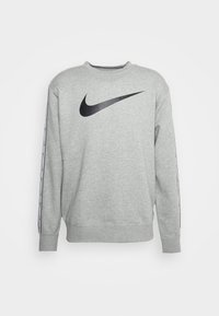 Grå sweatshirts i bomullsblandning, med en svart Nike-logga på framsidan och svarta sidostråk med vit text längs ärmarna.
