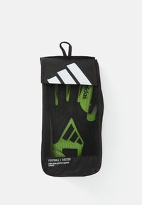 Mănuși de portar negre, păstrate într-un sac din plasă, având accente verzi și un logo Adidas alb proeminent în partea de sus.