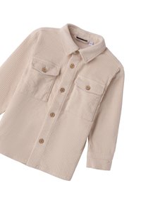 Chaqueta de camisa de canalé color beige, de manga larga, con cierre frontal de botones y dos bolsillos en el pecho con botón.