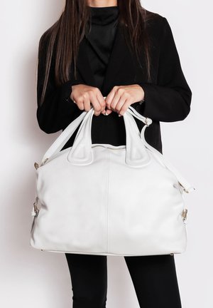 Borsa a tracolla in pelle bianca con silhouette arrotondata, doppi manici robusti, tracolla rimovibile e dettagli in metallo dorato.