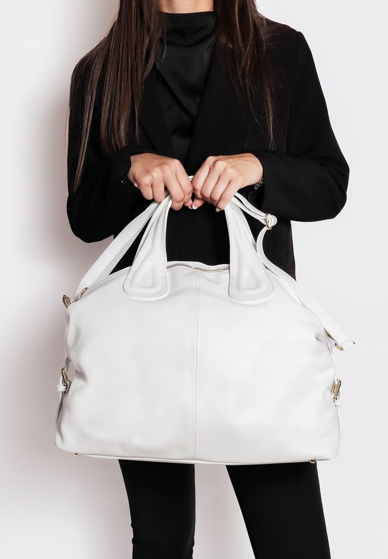 Borsa a tracolla in pelle bianca con silhouette arrotondata, doppi manici robusti, tracolla rimovibile e dettagli in metallo dorato.