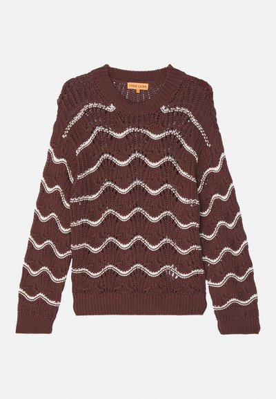 Brun striktrøje med et bølget hvidt mønster, rund halsudskæring og ribbede manchetter og kant. Har et løst, struktureret design.