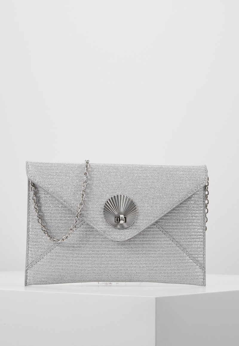 Srebrna torebka w stylu kopertówki o teksturowanej powierzchni, metaliczne zapięcie z motywem promieni słonecznych i łańcuszek na ramię.
