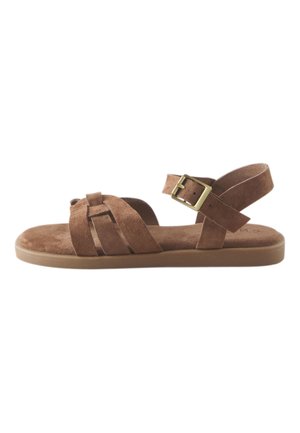 Brun ruskind flad sandal med flere stropper, en guldfarvet spænde og en polstret sål.