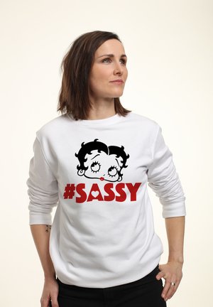 Biała bluza z kapturem z czarno-czerwonym rysunkiem postaci z kreskówki o wyrazistych oczach i czerwonych ustach, napis brzmi "#SASSY".