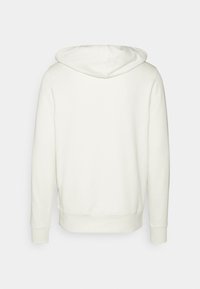 Sudadera con capucha en color blanco roto, con una textura suave, mangas largas y un diseño sencillo sin detalles frontales.
